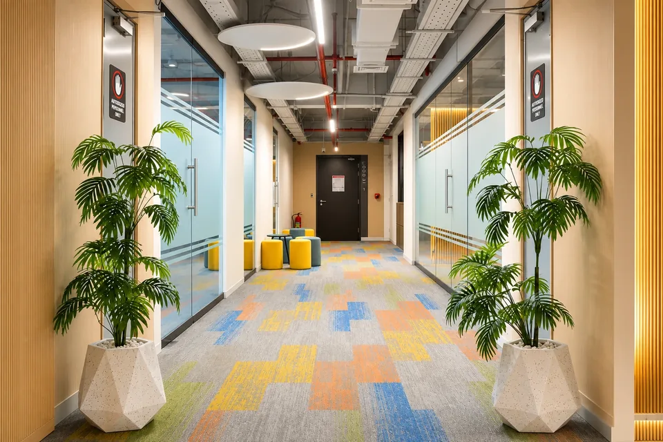 A SpaceShare corridor lined with glass office doors and planters